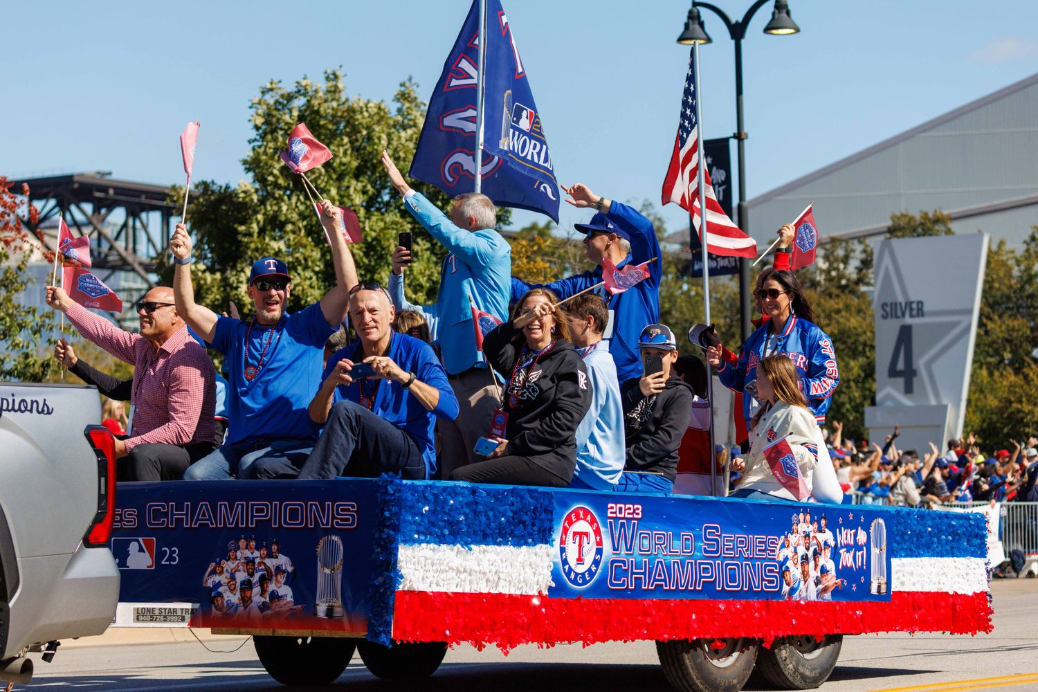 Eric Nadel, front and center, and the Texas Rangers radio team wave during the World Series championship parade at Globe Life Field on Nov. 3.